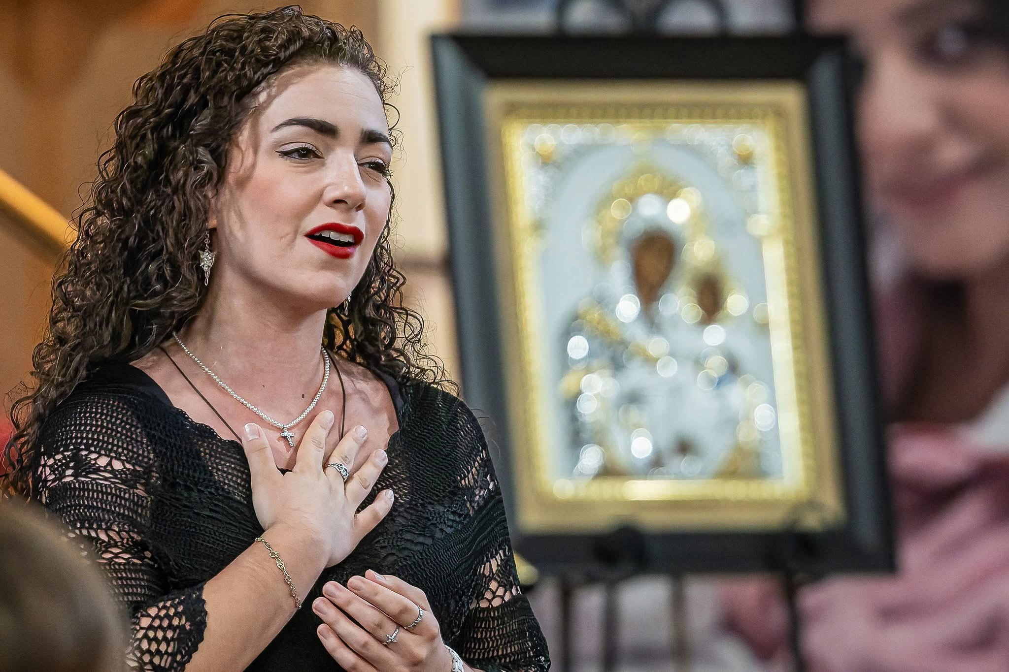 Christa Dalmazio singing at the benefit concert for Holy Family Hospital of Bethlehem, Marian icon behind her